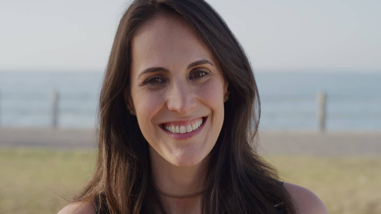 retrato de una mujer madura feliz sonriendo disfrutando de un cálido día de verano en la playa feliz independiente mujer en cámara lenta