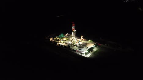 Panoramablick-über-Die-Beleuchtete-Gasbohrstation-Bei-Nacht---Drohnenaufnahme