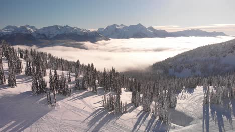 Aerial-descending-shot-over-a-snow-capped-mountain-in-Revelstoke,-British-Columbia