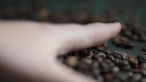 Hand-pouring-hot-steaming-coffee-beans