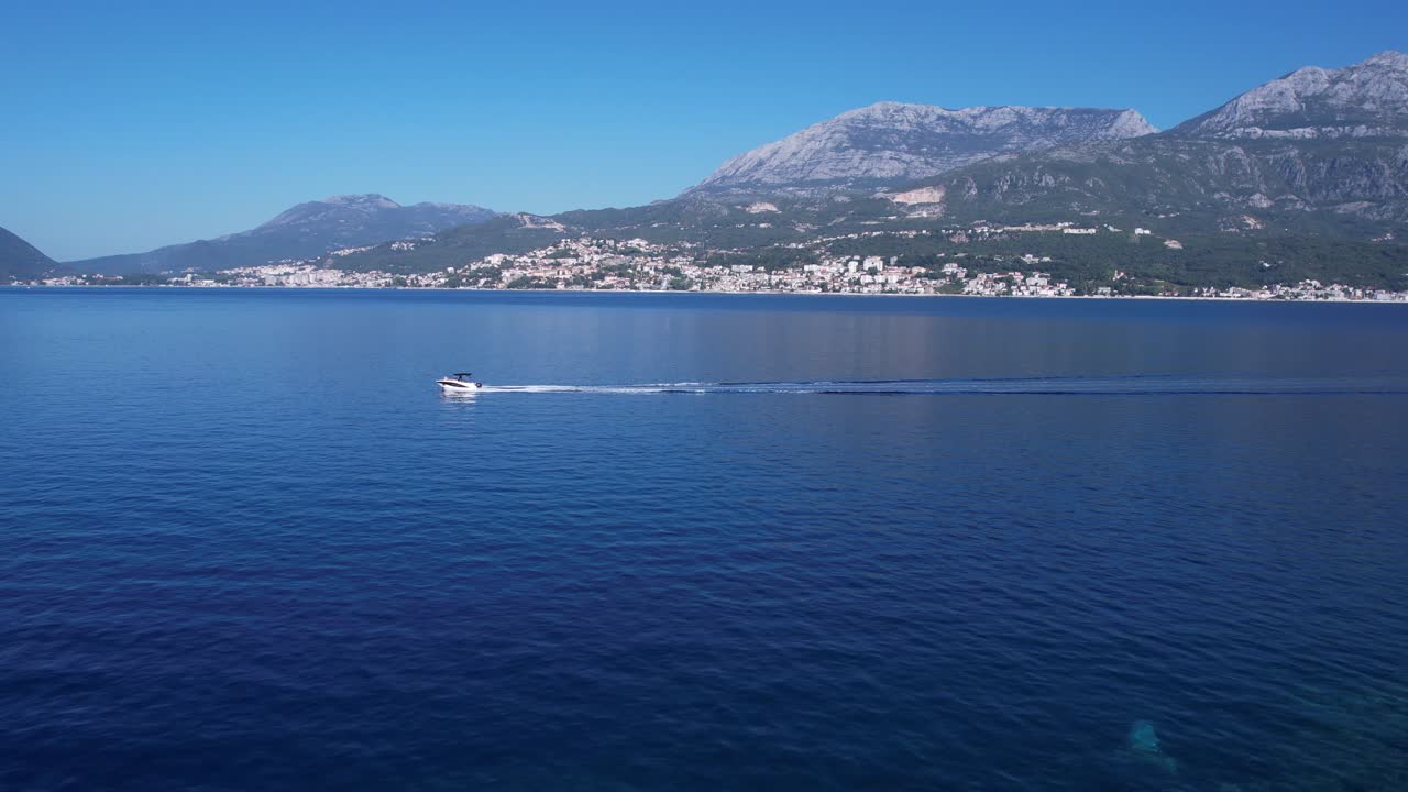 vista aérea, aldea de las rosas, barco en la bahía de kotor y la ciudad de herceg novi, edificios frente al mar en un soleado día de verano, montenegro