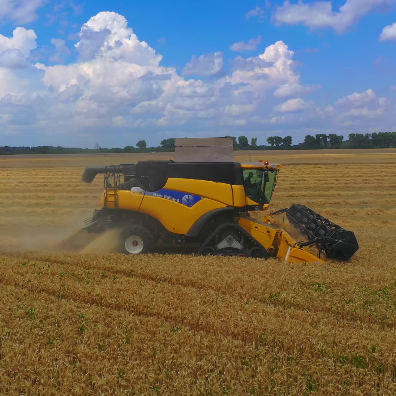 Yellow bulldozer harvesting in field