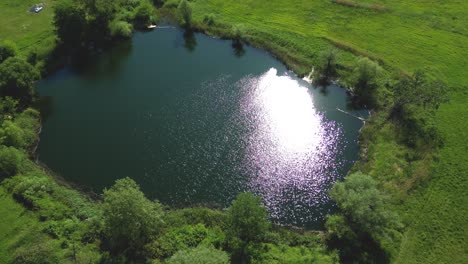 top view aerial flight over small lake of perfectly round shape