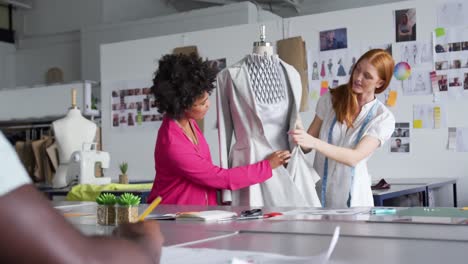 Two-women-dressing-up-a-model-in-fashion-office