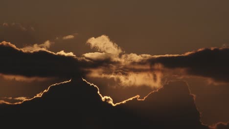 time lapse of sun setting behind clouds at sunset, static wide shot