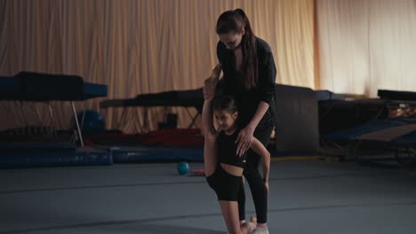 una joven entrenando en gimnasia con su entrenador