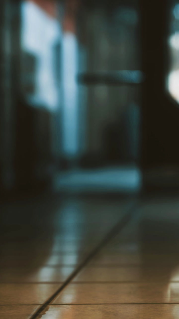 Reflections of light dance across the smooth floor in an empty hallway