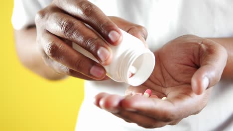 person taking pills from a bottle