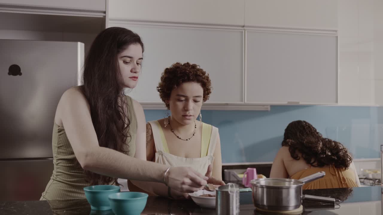 Women preparing food and using a smartphone in a kitchen
