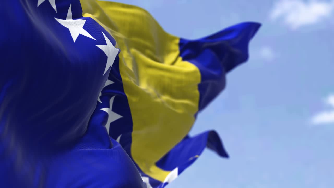 보스니아 헤르체고비나의 국기가 은 날 바람에 흔들리는 모습.