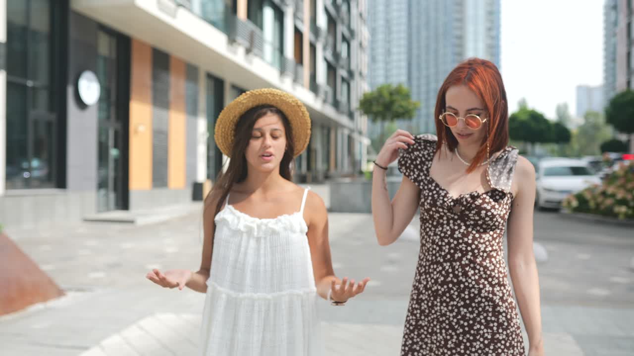 두 명의 젊은 여성이 도시 거리에서 고 이야기하고 있습니다.