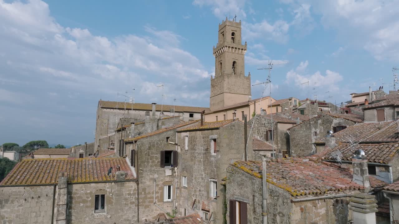 Aerial Drone view of the hilltop Medieval town of Pitigliano, Tuscany in morning light, flying low over red tile roofs and old buildings, in 4K