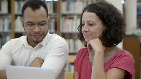 cheerful student working over new project at library