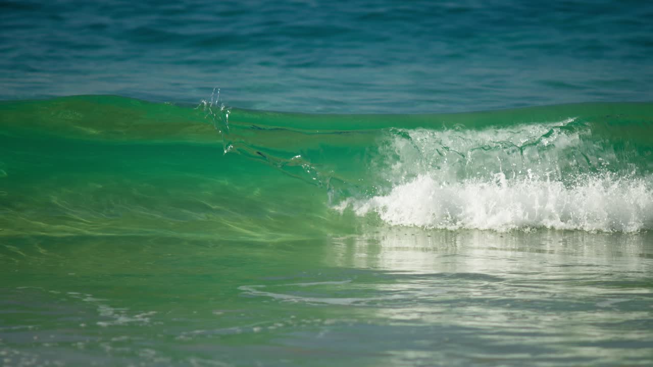 SLOW MOTION CLOSE UP SHOT OF A TURQUOISE WAVE