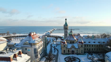 Touristische-Highlights-Mit-Leuchtturm,-Langgestrecktem-Pier-Ins-Meer-Und-Historischen-Gebäuden-In-Der-Innenstadt-Von-Sopot,-Die-An-Einem-Sonnigen-Wintertag-Im-Lockdown-Mit-Weißem-Schnee-Bedeckt-Sind