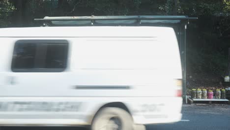 vehicles passing by a girl in face mask sitting and waiting on bus stop during covid-19