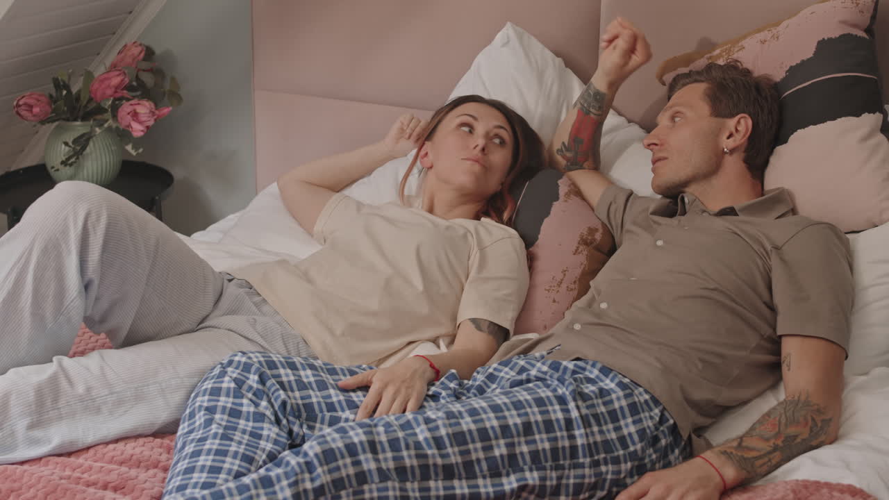 Woman and Man Relaxing in Bed