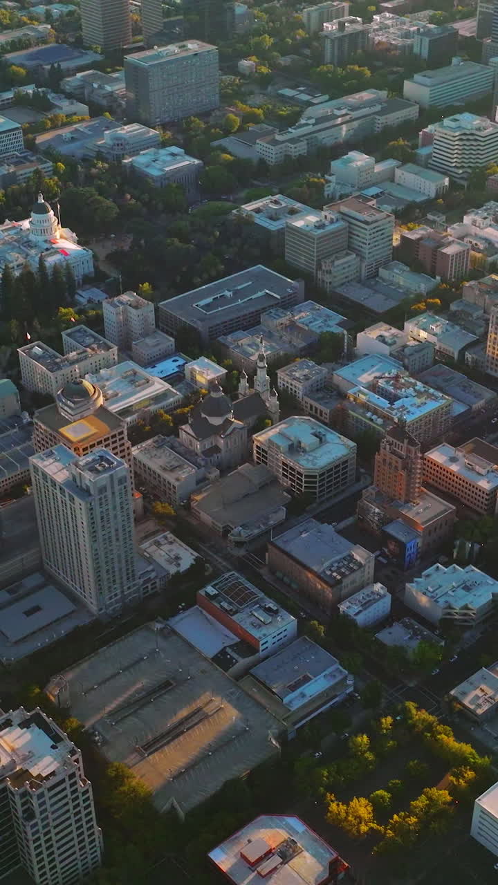 Sacramento city architecture full of greenery from aerial perspective. Drone footage over the city at sunset. Vertical video