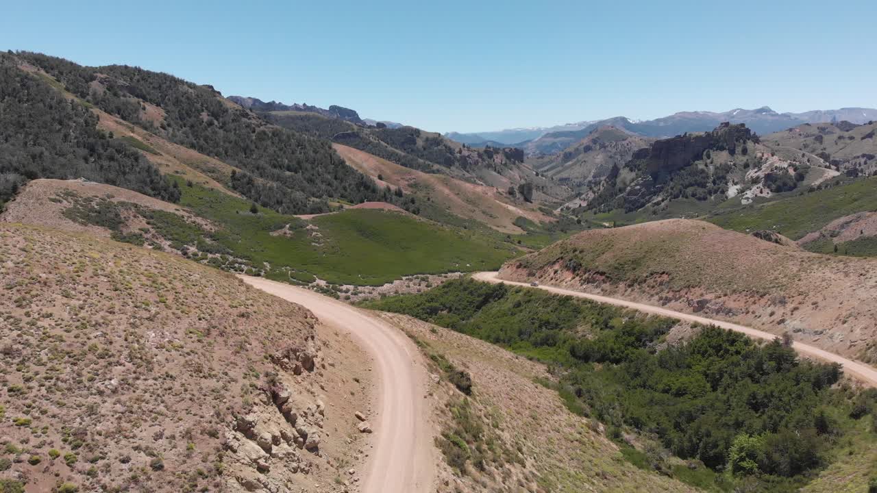 camino de tierra rural en las montañas, una camioneta se mueve a distancia