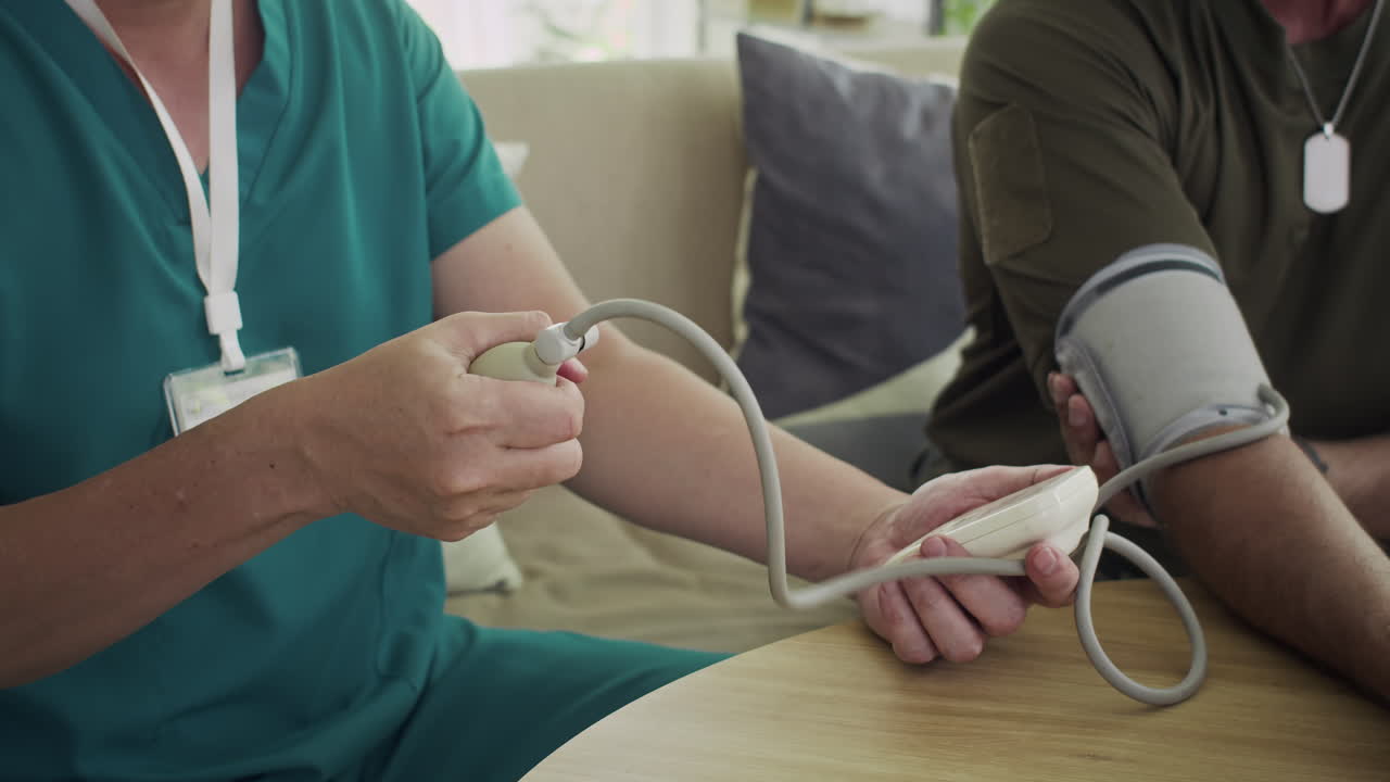 Unrecognizable Medical Worker Examining Blood Pressure of Ex-soldier
