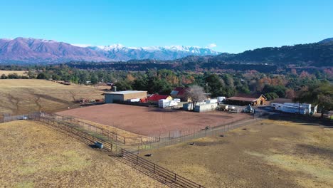 aerial over farm fields reveals the ojai valley and snow covered topatopa mountains in winter