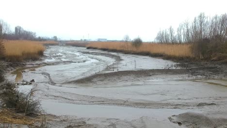 rising aerial dry river muddy landscape puddle misty cloudy day