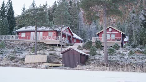 hüttenhäuser auf einem hügel mit kiefern im winter in norwegen