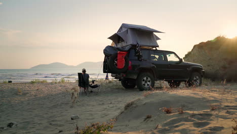 A-woman-with-her-dog-camping-on-a-beach