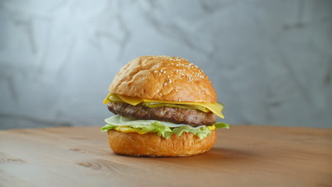 a big tasty burger with meat patty onions vegetables melted cheese lettuce