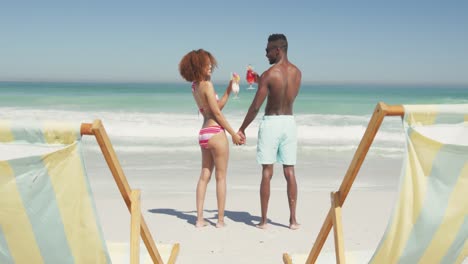 African-american-couple-drinking-cocktail-seaside