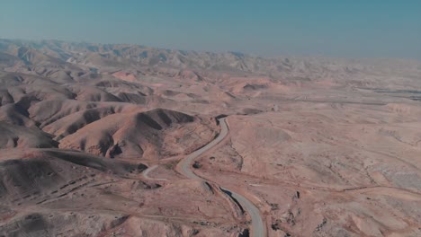 drone shot of a desert with hills, roads, blue sky