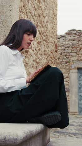 woman reading the bible book and flipping pages at the entrance of the church