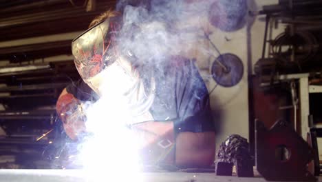 soldador trabajando en una pieza de metal