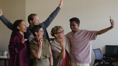 diverse group of happy friends or colleagues taking a selfie
