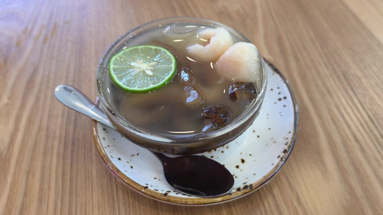Uma tigela refrescante de sobremesa de coco do mar gelado está pronta para ser servida. Calda doce gelada e fatias de fruta macias criam o deleite perfeito. É incrivelmente deliciosa para desfrutar em tempo quente.