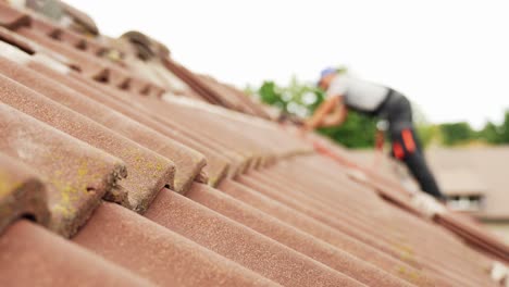 Verschwommener-PV-Arbeiter,-Der-Solarpanel-Auf-Dem-Dach-Installiert,-Fokus-Auf-Fliesen