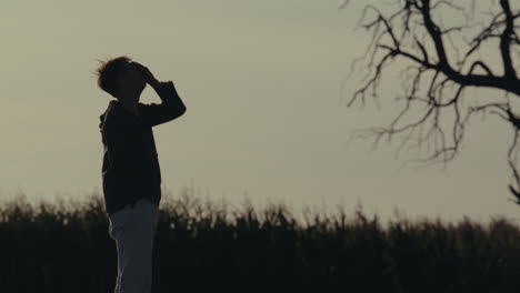 silhouetted person in a field at dusk