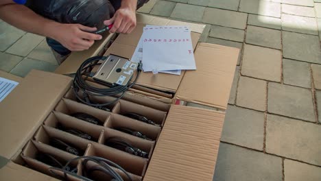 an electrician marking up the electric circuit breakers on paper outdoor