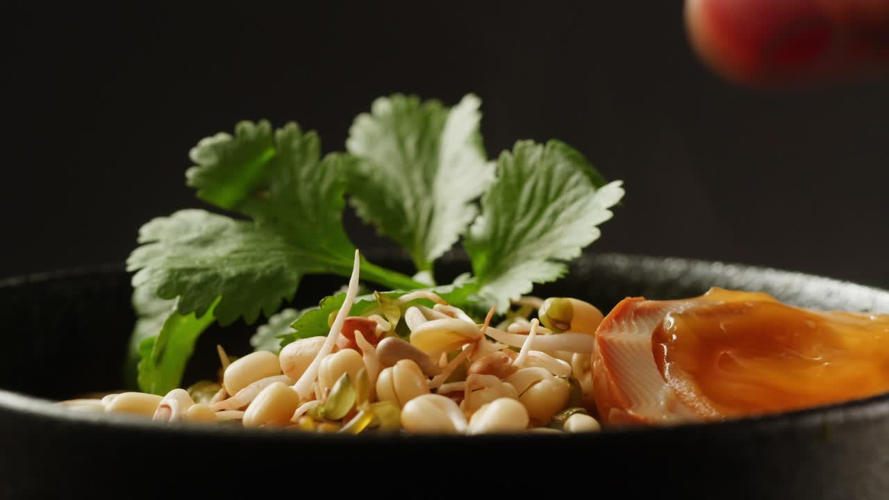 Preparing a bowl of delicious soup with egg and herbs
