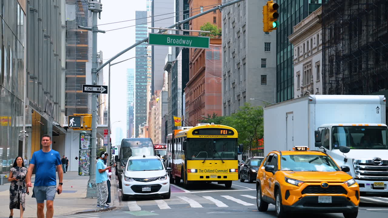 New York, USA, 1 August 2025: Busy Broadway avenue with yellow taxis, buses, and people walking in Manhattan