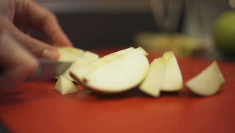 close up of a woman's hand chopping apples into slices