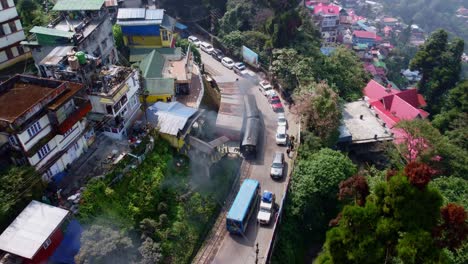 darjeeling himalayan railway steam engine toy train through city neighbourhood, west bengal, drone shot
