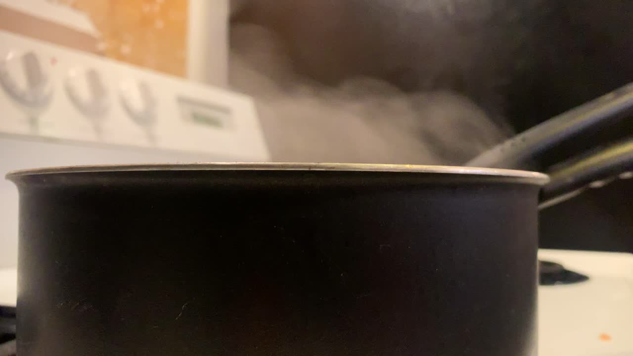 breve clip de fideos hirviendo y el stgeam saliendo de la olla hirviendo