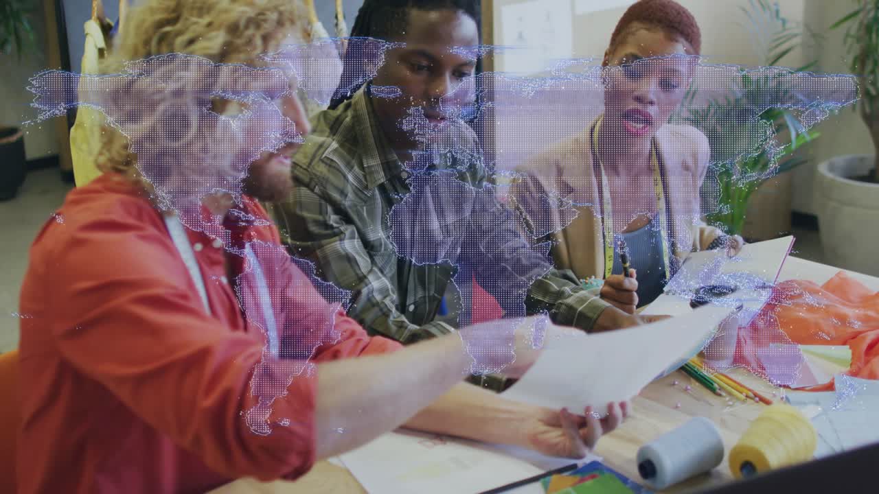 Lifting printed document from desk adult man in red shirt guiding colleagues through design review