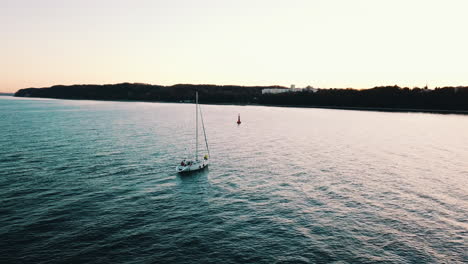 drohne fliegt über die yacht, die bei sonnenuntergang in gdynia in die bucht segelt