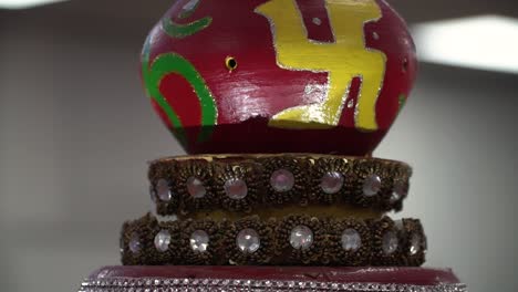 close up of turning hindu lamp with om and swastika symbols during havan ceremony