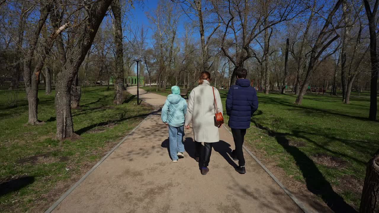 Famiglia che cammina insieme su un sentiero in un parco in una giornata soleggiata