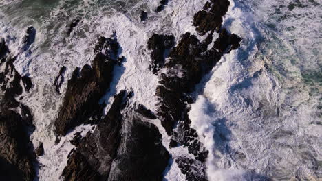 Agua-De-Mar-Espumosa-Mientras-El-Océano-Turbulento-Choca-Contra-Las-Rocas