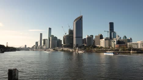 Wide-view-of-Brisbane-City-in-the-afternoon-light-as-a-CityCat-arrives-at-QUT-Ferry-Terminal,-Queensland,-Australia