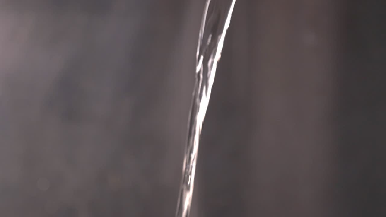 Pouring Water And Splashes On A Blurry Background. - close up shot